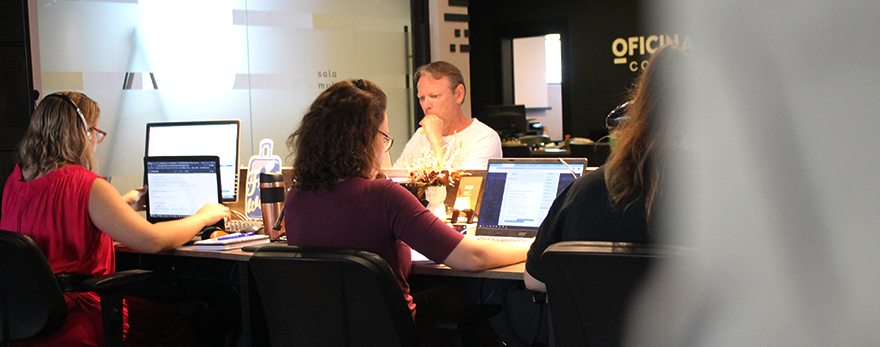 Fotografia ilustrativa de pessoas trabalhando ao redor de uma mesa em um coworking e startups.