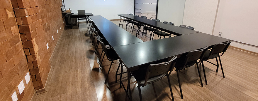Fotografia ilustrativa da sala multiuso do Oficina670 em Lajeado - reunião de negócios para cerca de 14 pessoas.
